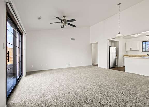 A spacious living room with a ceiling fan and carpeted floor at Tanglewood Apartments, Oak Creek, WI