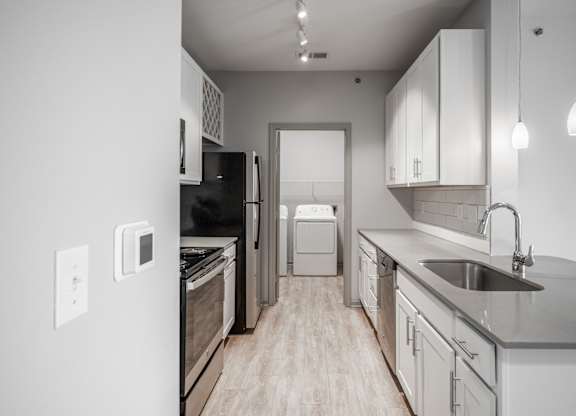 A modern kitchen with a black refrigerator and stove.