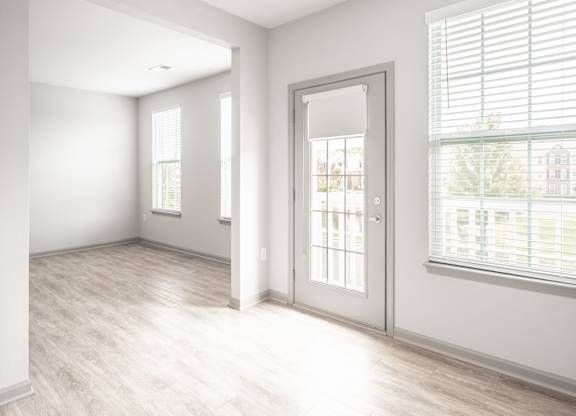 A room with a white door and a window with blinds.