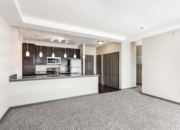 A kitchen with a refrigerator, microwave, and oven.