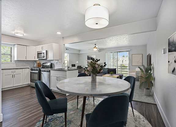 A modern kitchen with a dining table set for four at Byron Lakes Apartments in Byron Center, MI