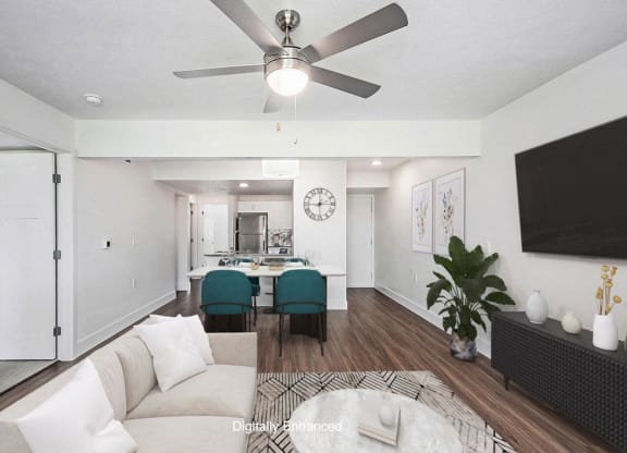 a living room with a ceiling fan and hard surface floors at The Crossings Apartments, Michigan, 49508
