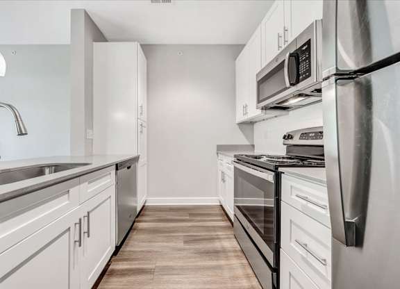 A modern kitchen with stainless steel appliances and white cabinets at The Retreat Apartments, Roanoke, 24019
