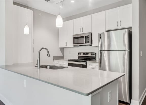 A modern kitchen with stainless steel appliances and white cabinets at The Retreat Apartments, Roanoke, 24019