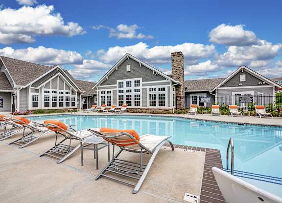 A pool with chairs and a building in the background at The Retreat Apartments, Roanoke, 24019