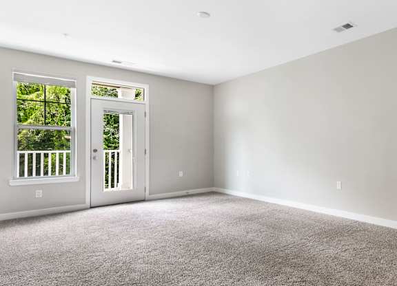 A room with a carpeted floor and two doors, one of which is open at The Retreat Apartments, Roanoke, 24019