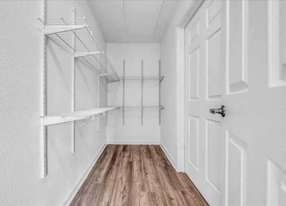 the closet in a bedroom with white walls and wood flooring at The Vinings Apartments in Richmond, VA 