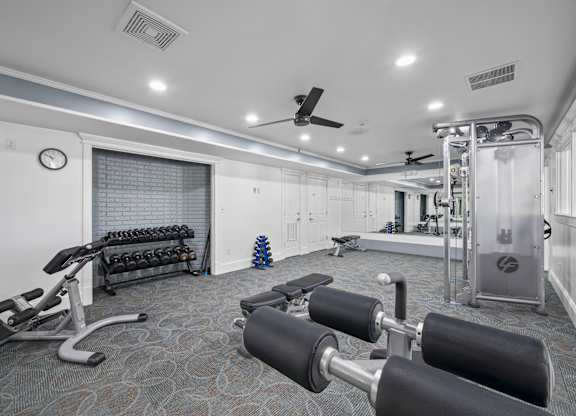 A gym with a variety of equipment including weights and a bench pressk at Timberlane Apartments, Peoria, Illinois