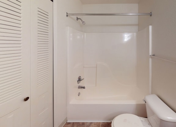 a bathroom with a toilet and a tub and a shower  at Tracy Creek Apartment Homes, Perrysburg, Ohio