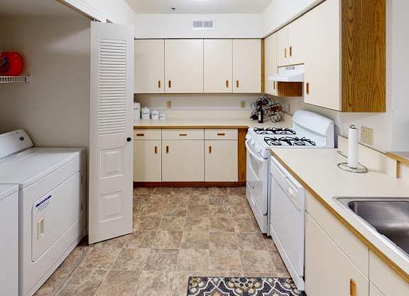 A kitchen with white appliances and wooden cabinets at Tracy Creek Apartment Homes in Perrysburg, OH
