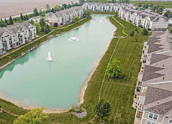 A large pond with fountains in the middle of an apartment development at Tracy Creek Apartments, Perrysburg