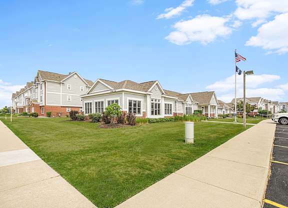 A leasing office and community building with a flag on a pole in front at Tracy Creek Apartments, Perrysburg