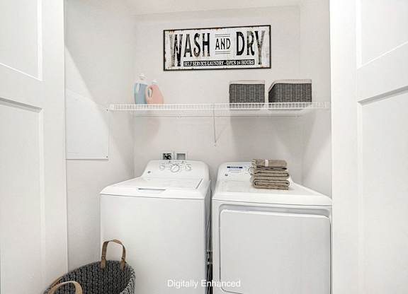 A laundry room with a full size washer and dryer at Trade Winds Apartment Homes, Elkhorn, Nebraska