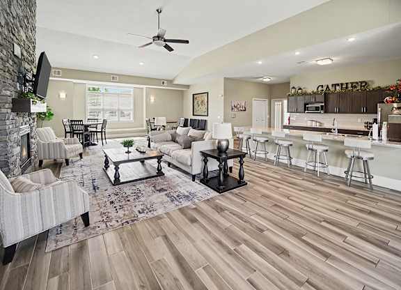 A clubhouse with a fireplace and a dining table at Trade Winds Apartment Homes, Elkhorn, NE, 68022