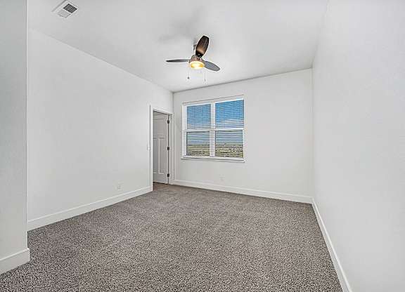 bedroom with a large window and ceiling fan at Trade Winds Apartment Homes, Elkhorn, NE