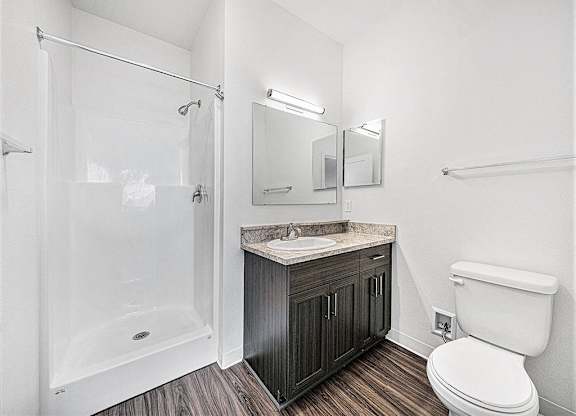 a bathroom with a shower toilet and a sink at Trade Winds Apartment Homes in Elkhorn, NE 68022