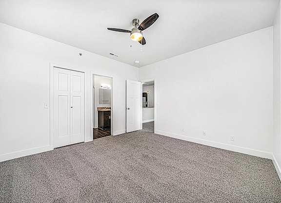 an empty bedroom with a ceiling fan at Trade Winds Apartment Homes in Elkhorn, NE 68022