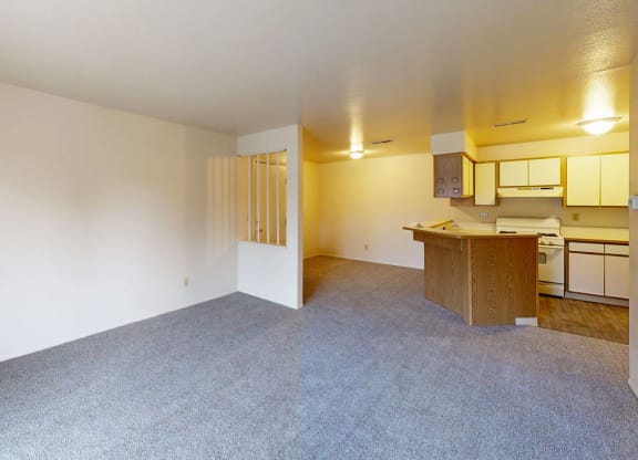 living and dining room with plush carpeting  at Trappers Cove Apartments, Lansing, MI