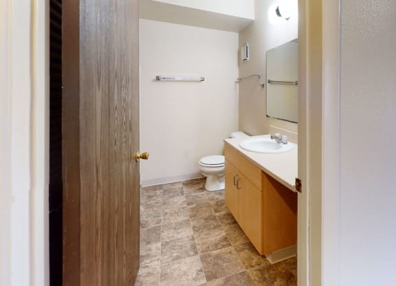 a bathroom with a toilet and a sink  at Trappers Cove Apartments, Lansing, Michigan