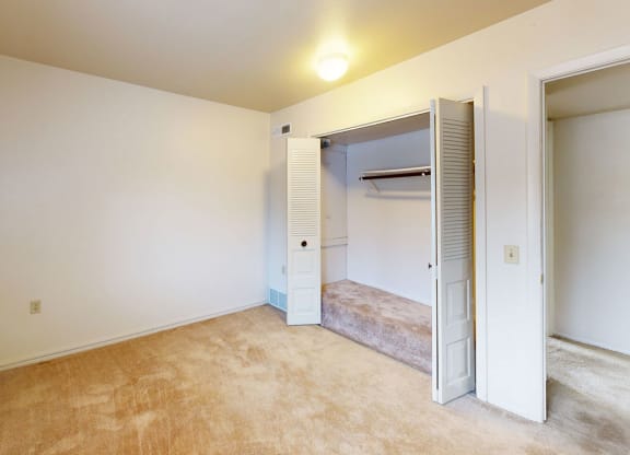 a bedroom with a large closet at Trappers Cove Apartments, Lansing, 48910