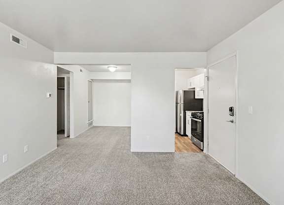 A spacious, empty dining room with a breakfast bar at Trappers Cove Apartments, Lansing