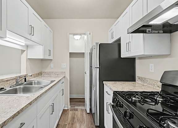 An upgraded gallery style kitchen with stainless steel appliances and a pantry at Trappers Cove Apartments, Lansing