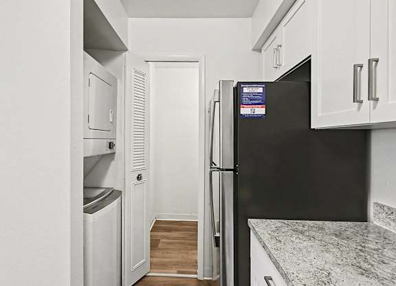 A kitchen with a washer and dryer and a pantry at Trappers Cove Apartments, Lansing
