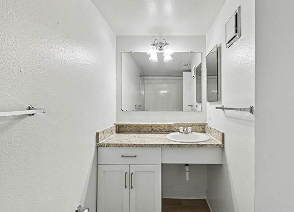 An upgraded bathroom with a sink and mirror at Trappers Cove Apartments, Lansing