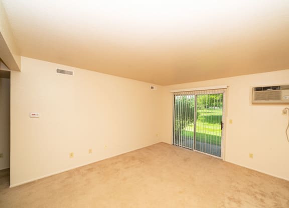 Living Room Leads to Private Patio at Trappers Cove Apartments, Lansing, MI, 48910