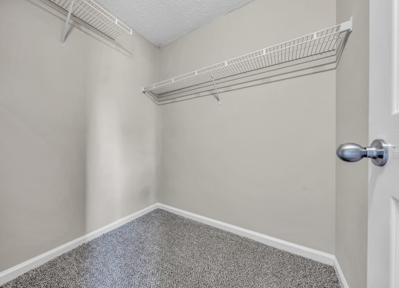an empty closet with an open door and a shelf on the wall at Trophy Club at Bellgrade, Midlothian, VA, 23113