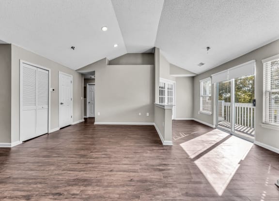 an empty living room with windows and a balcony at Trophy Club at Bellgrade, Midlothian, VA, 23113