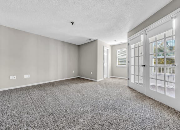 the living room and entryway of a house with white doors at Trophy Club at Bellgrade, Midlothian, VA, 23113
