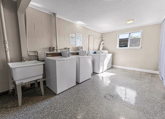A kitchen with a dishwasher, sink, and a window