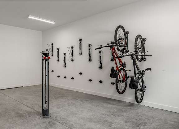 A white wall with a red bike hanging on it.