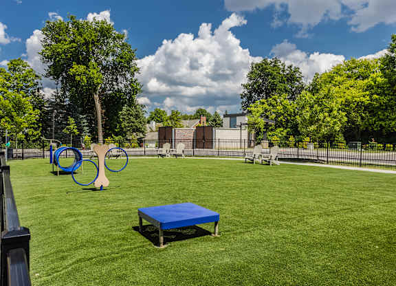 A playground with a blue mat and a swing set.
