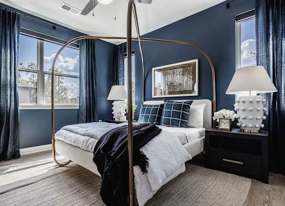 A bedroom with a four poster bed and a ceiling fan.