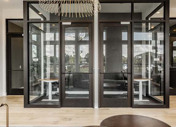 A modern interior with a glass door and a round table.