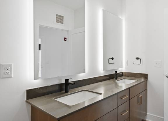A bathroom with a sink, mirror, and cabinets at Upper Vue Flats, Dublin