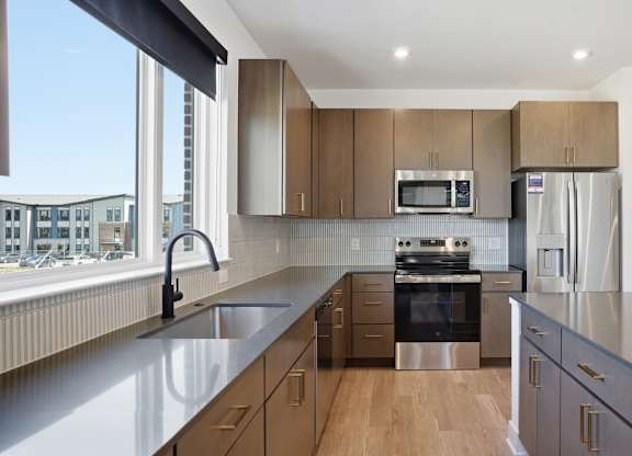 A modern kitchen with wooden cabinets and stainless steel appliances at Upper Vue Flats, Dublin