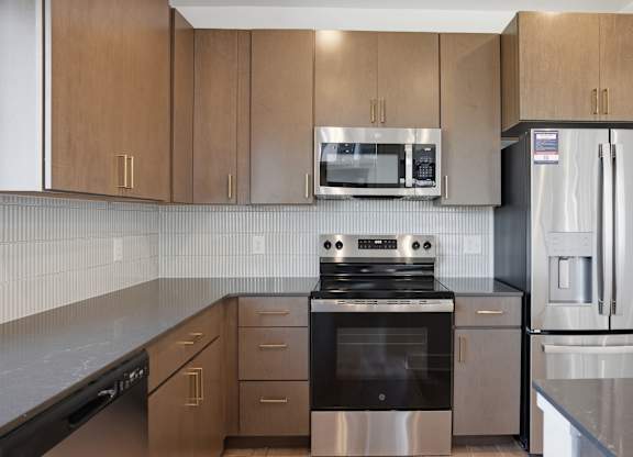 A kitchen with a stove, refrigerator, and microwave at Upper Vue Flats, Dublin