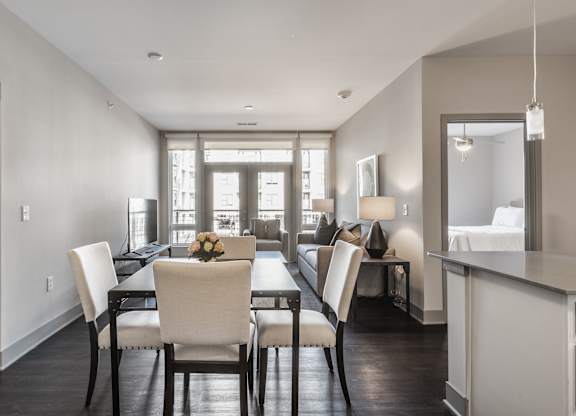 A modern dining room with a table set for four.