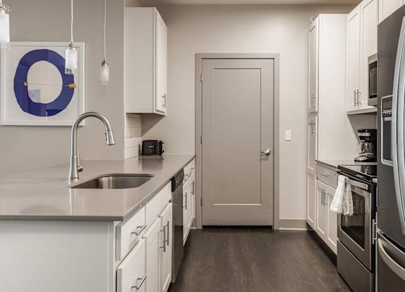 A kitchen with a sink and a refrigerator.