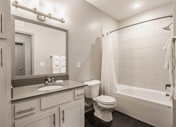 A bathroom with a toilet, sink, and bathtub.