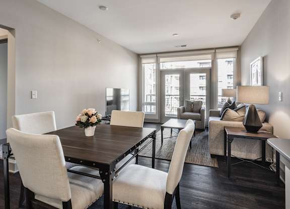 A modern dining room with a wooden table and chairs.