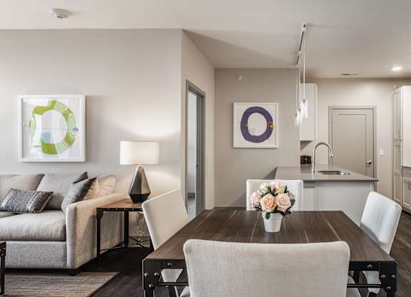 A modern kitchen with a dining table set for two.