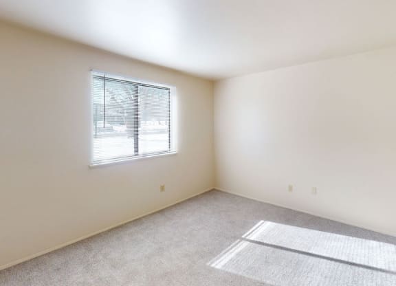 bedroom with a window and plush carpeting at Walnut Trail Apartments in Portage, MI 49002