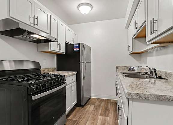 A kitchen with stainless steel appliances and white shaker cabinets at Walnut Trail Apartments, Michigan