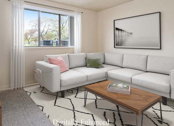 A garden style living room with a grey couch, a wooden coffee table, and a large window with curtains at Walnut Trail Apartments, Portage, MI, 49002