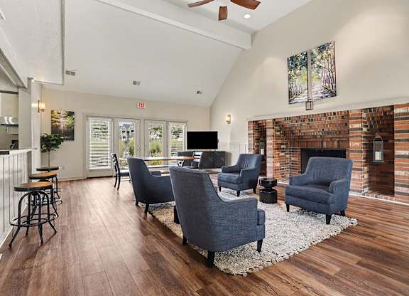 A community room with a fireplace and a painting on the wall at Walnut Trail Apartments, Michigan