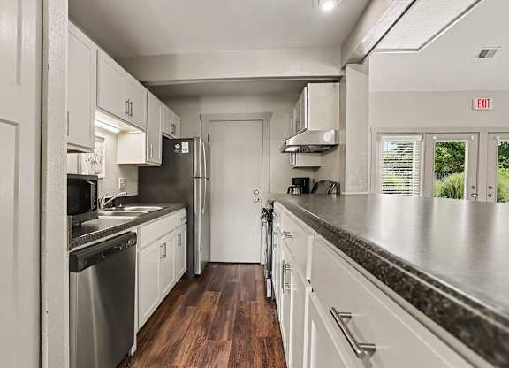 A community kitchen with white cabinets at Walnut Trail Apartments, Michigan